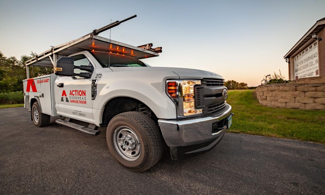 Action Overhead service truck parked outside a house ready to service a garage door